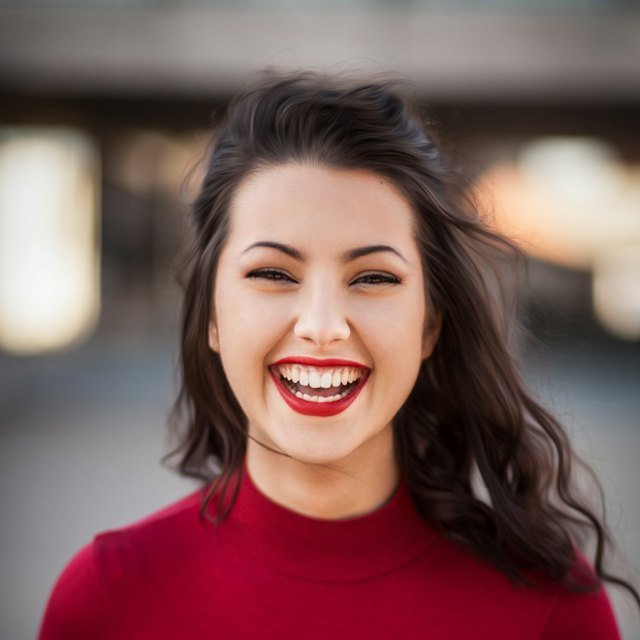 Laughing woman with long dark hair in a red sweater