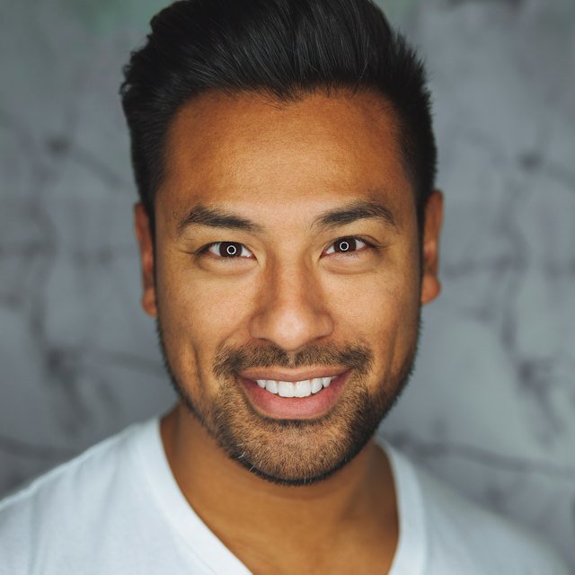 Smiling man with short dark hair and a white t-shirt